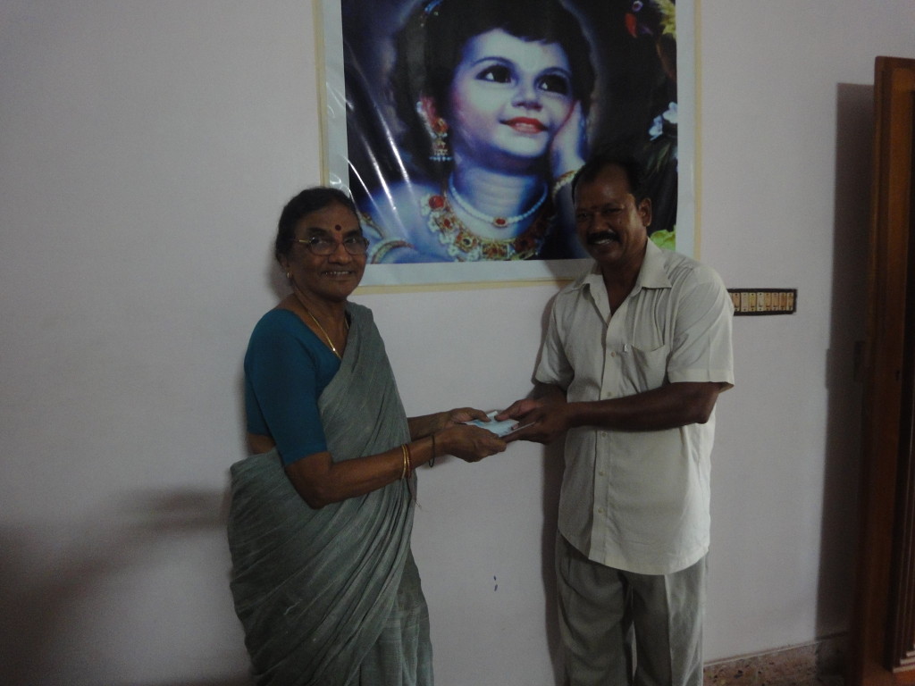 Mrs. Vasantha Devanathan, parent of Trustee, handed over an educational-aid cheque to Ramesh, who earn livelihood by ironing, to pay for his daughter Kiruthika’s CSE third-year annual fees