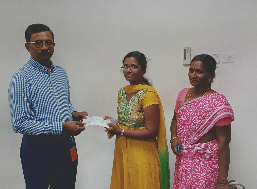 The Trustee has handed over an educational aid cheque to Sournabagavathi for her B.Com. first-year studies.
